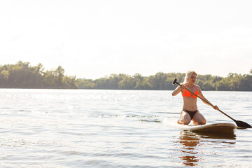 A beautiful woman practicing paddle on a beautiful sunny day