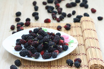 Beautiful purple Mulberry berry in a white plate
