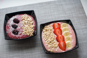 Two delicious smoothie bowls on a grey table