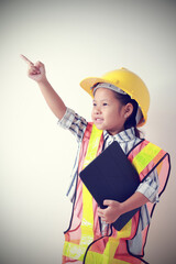 Portrait asian kid girl wearing reflective shirt and hard hat safety she holding tablet. To learning and enhance development, little architect.