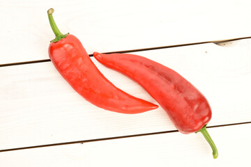 Red sweet organic peppers, close-up, on a wooden table.