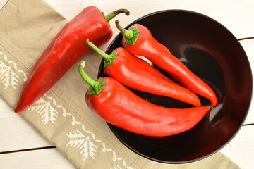 Red sweet organic peppers, close-up, on a wooden table.