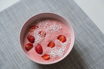 Delicious smoothie bowl in pink bowl on a grey table