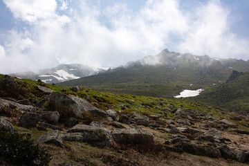 Snowy mountains that begin to melt and become green with spring and around