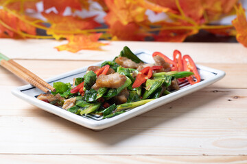Stir fried crispy pork kale on a plate on a wooden background