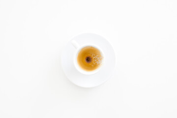 Finished cup of espresso coffee on a white table