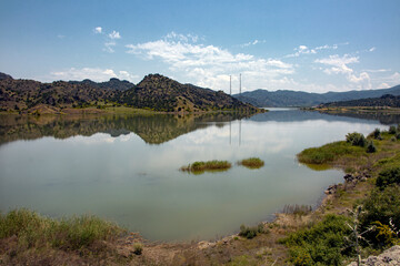 summer landscape, the river meanders and goes into perspective one bank of the river is steep and another gentle, reed thickets