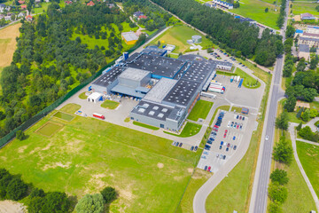 Aerial Top View of Industrial Storage Building Area with Solar Panels on the Roof and Many Trucks...