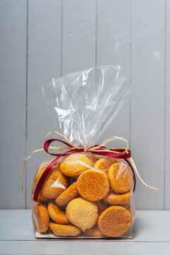 Cookies in a transparent bag on a white background. Homemade gingerbread in the package. Homemade cakes on wooden background