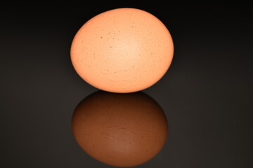 One chicken egg, macro, isolated on a black background.