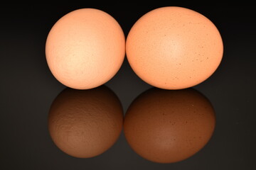 Several chicken eggs, close-up, isolated on a black background.