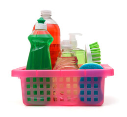 Plastic bottles of cleaning products, sponges and brush in basket on white background