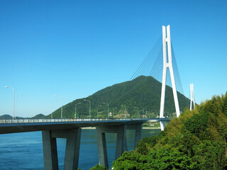 Obraz premium The Tatara Bridge (多々羅大橋, Tatara Ohashi) above Seto Inland Sea, JAPAN. A cable-stayed bridge as part of Shimanami Kaido expressway and cycling route