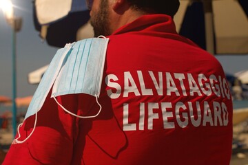Fototapeta na wymiar Lifeguard holding surgical mask , concept of Healthy lifestyle at the beach