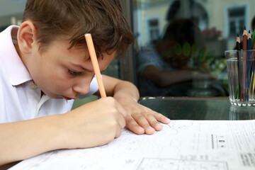 Boy drawing with pencil on terrace