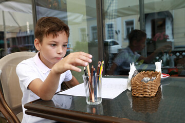 Child drawing with pencil on terrace
