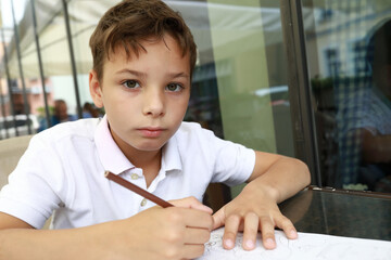 Child painting with pencil on terrace