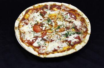  Pizza with salami sausage, tomato, syrup and dill on a white plate