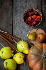 Autumn still life on a wooden table top view. Pumpkin, chestnuts, acorns, quince, nuts, cones. Rustic background. Quince and pear. Basket close-up.