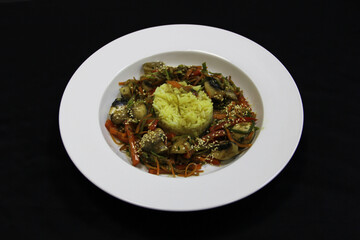 Rice and salad of mushrooms, seaweed, pepper and carrots on a white plate