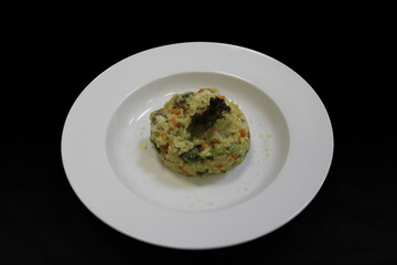 Rice with vegetables on a white plate. Close