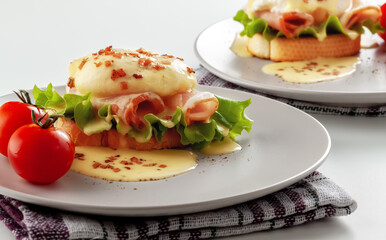 Eggs Benedict on toasted muffins with ham and sauce