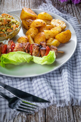 Shish kebab served with roasted potatoes and salad.