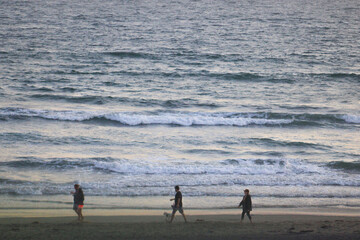 Fototapeta na wymiar People Walking on the Beach