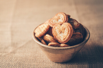 Homemade heart shaped sugar biscuit in wooden bowl