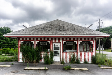 Front of an aged and worn exterior of abandoned store selling ice cream.