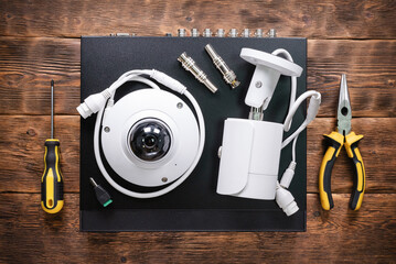 Modern white security cameras and video recorder on the table. Video surveillance concept...