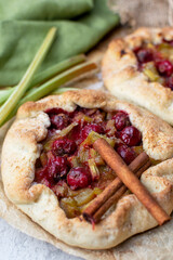 Rustic sweet cherry rhubarb galette on baking paper.