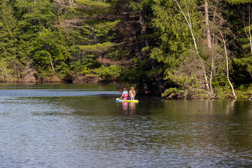 Fototapeta na wymiar girls paddle boarding on lake