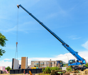 Construction site of a prefabricated house with mobile crane