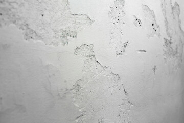 A ragged brick wall. Peeling putty, cement, paint. Unloaded wall, preparation for repair. Texture, cracked, chipped.