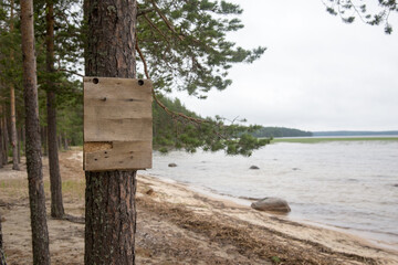A sign on a tree near the water, mock-up. Karelia.