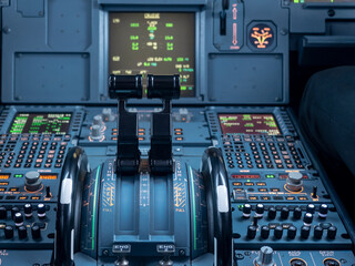 Airbus A320 thrust levers on the centre pedestal instrument panel. Switches and dials visible in the background. 