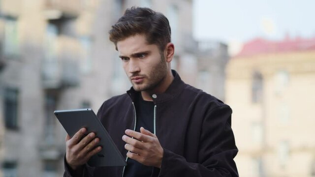 Evil guy having video call outside. Angry man using tablet outdoors