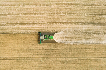 Modern combine harvester working on the wheat crop. Aerial view.