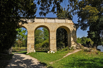 Fototapeta na wymiar Old stone viaduct in the castle garden of Lednice castle
