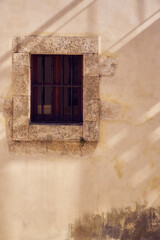 A window on a vintage wall with shadows.