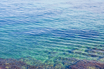 Fototapeta na wymiar Texture of a clear transparent tropical Sea water on the coast of Crete, Greece as a natural background.