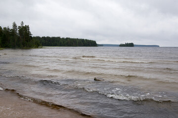 Sandy shore of the lake near the forest in Karelia