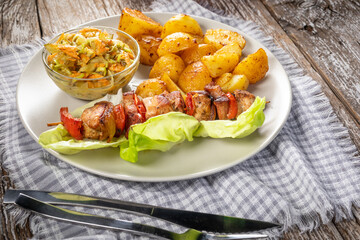 Shish kebab served with roasted potatoes and salad.