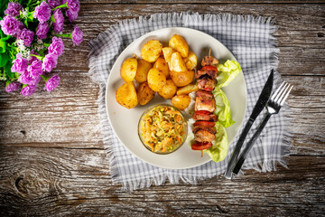 Shish kebab served with roasted potatoes and salad.