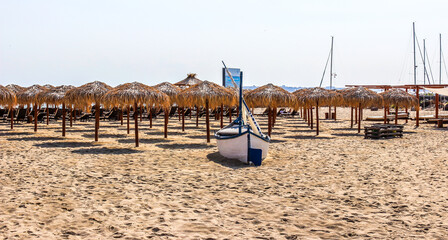 Beach with straw umbrellas.