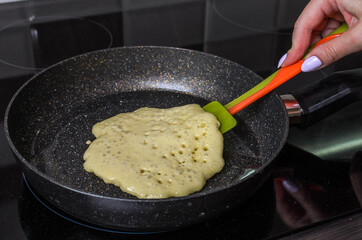 Cook fries pancakes in a pan on an induction cooker	
