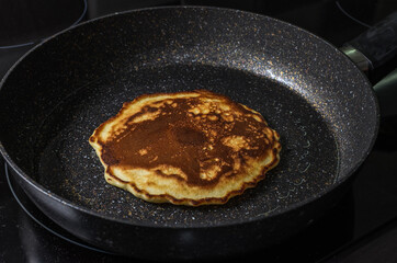Cook fries pancakes in a pan on an induction cooker	
