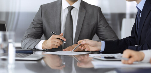 Unknown business people working together at meeting in modern office, close-up. Businessman and...