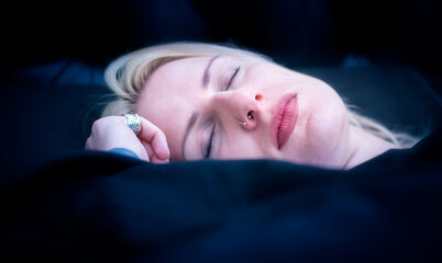 Sleeping blonde caucasian woman with a piercing